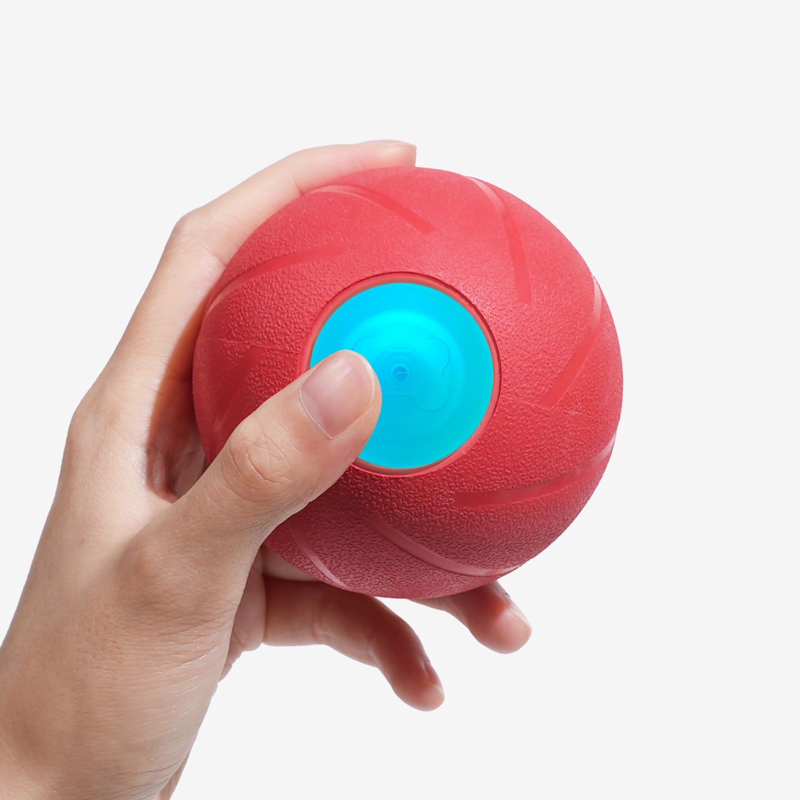Hand holding red Wicked Ball PE dog toy with blue center